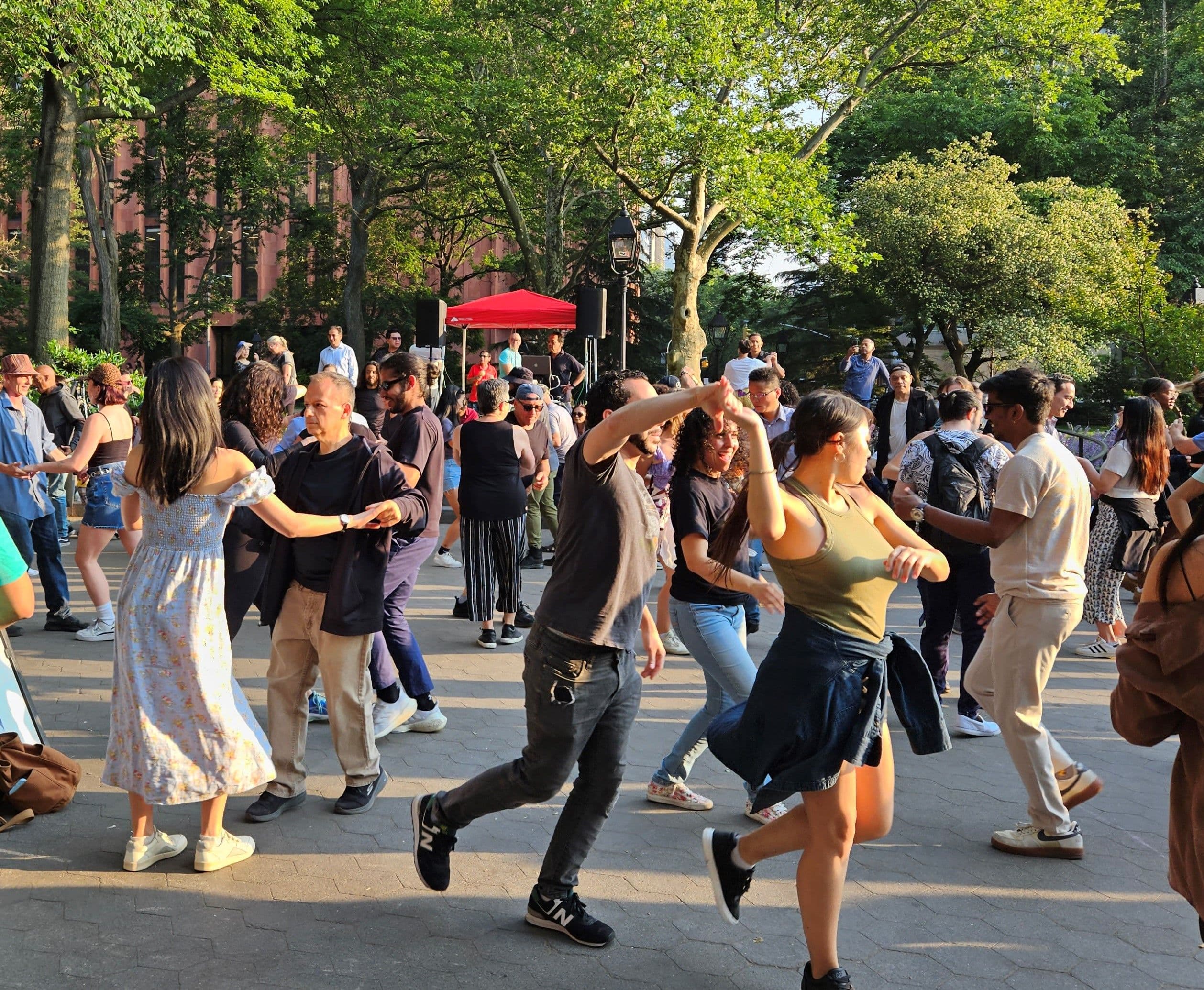 Hundreds of people dance salsa in Washington Square Park.