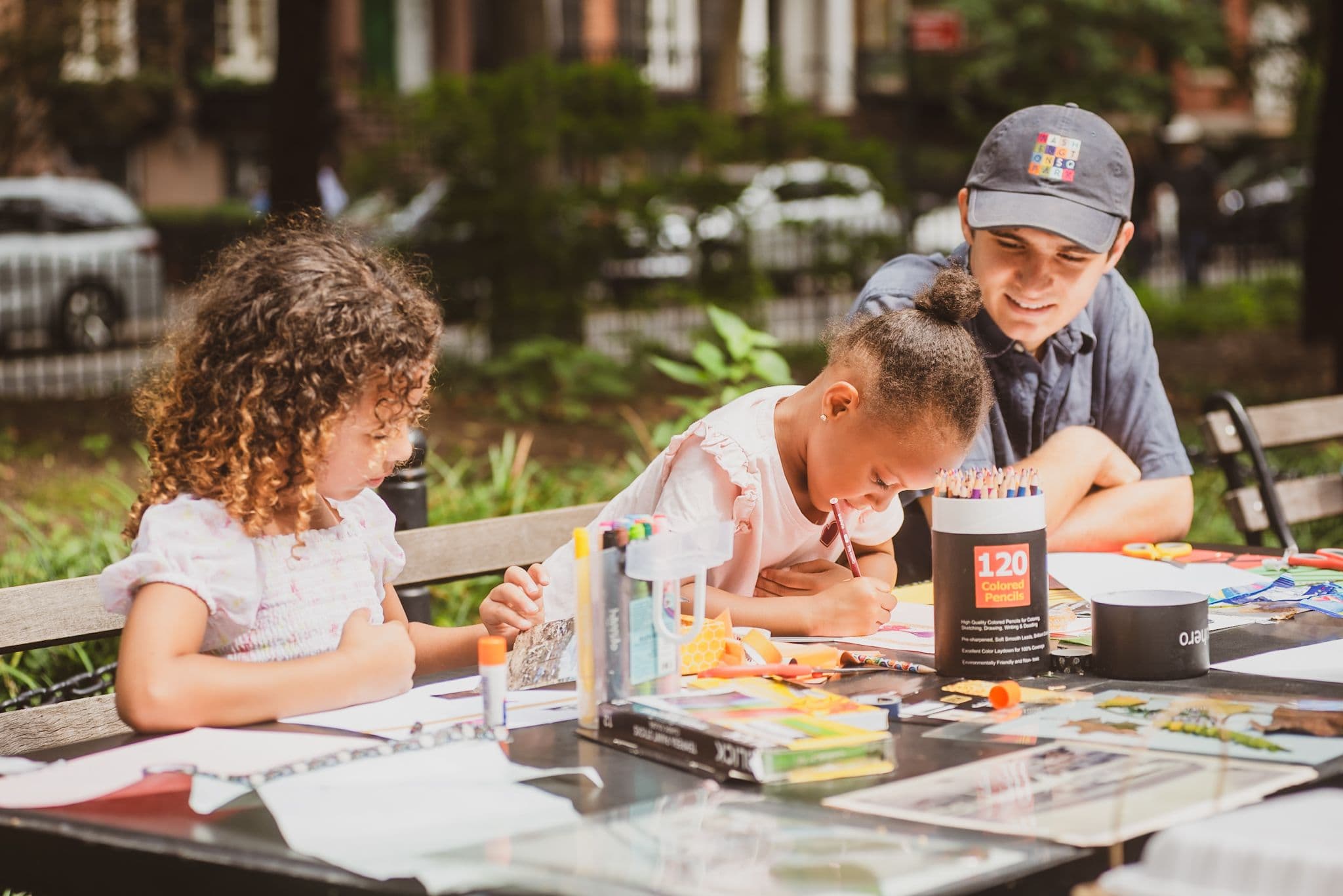 Two children work with a Conservancy team member at a Park Open Studio art workshop.